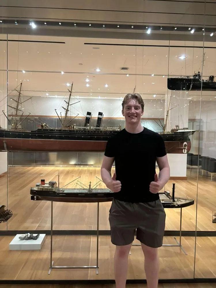 Michael Quick in front of a model ship.